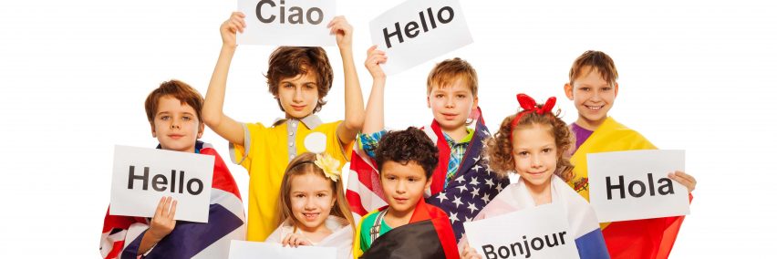 Kids wrapped in flags of USA and European nations, holding greeting signs in different languages, isolated on white