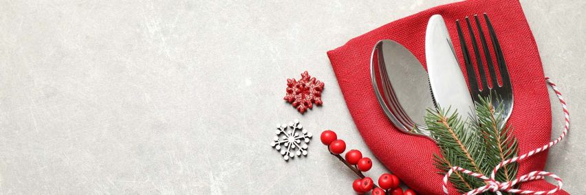 Cutlery set and festive decor on light grey table, flat lay with Cutlery set and festive decor on light grey table, flat lay with space for text. Christmas celebration